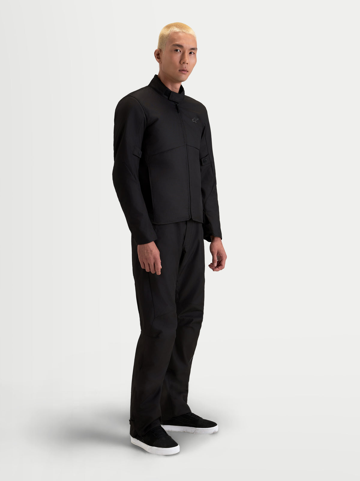 Alpinestars C-1 Waterproof Chaqueta, chaqueta de moto urbana y contemporánea de tejido textil para hombre en color negro, vista lateral en modelo con pantalones a juego