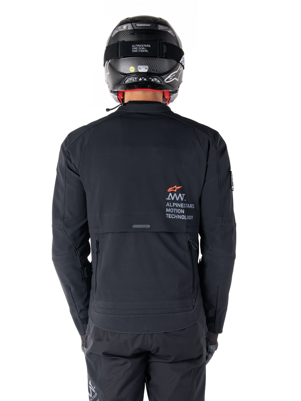 Chaqueta Alpinestars AMT-8 Stretch Drystar® XF, vista trasera, negra, usada con casco y pantalones negros, con el logotipo Alpinestars Motion Technology en la parte posterior, diseño de adventure touring con material elástico ergonómico.