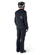 Chaqueta Alpinestars AMT-8 Stretch Drystar® XF, negro, vista trasera de un piloto que lleva la chaqueta con pantalones negros a juego y casco negro, con la marca 'Alpinestars Motion Technology' en la espalda, material elástico técnico para conducción de aventura