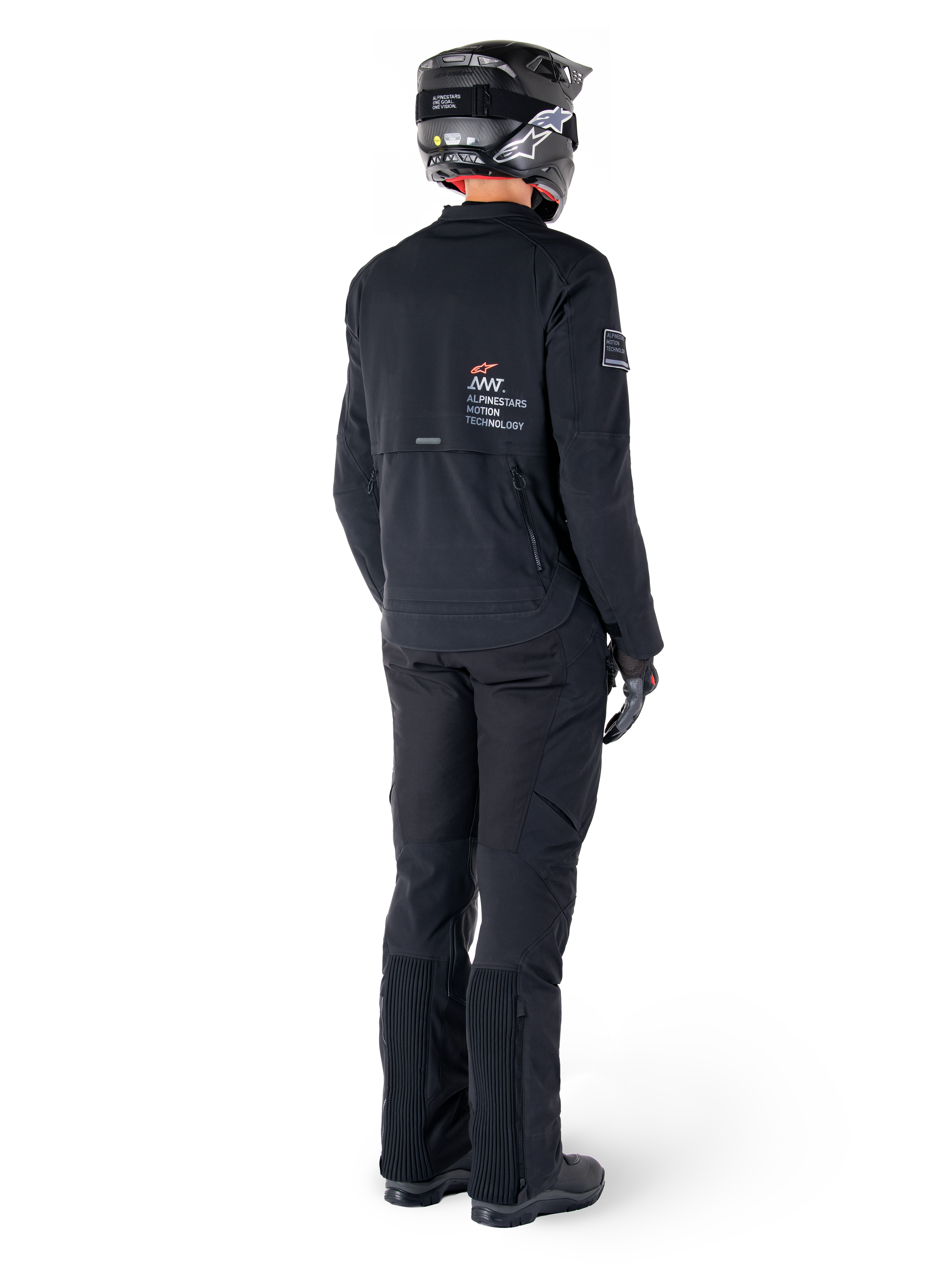 Chaqueta Alpinestars AMT-8 Stretch Drystar® XF, negro, vista trasera de un piloto que lleva la chaqueta con pantalones negros a juego y casco negro, con la marca 'Alpinestars Motion Technology' en la espalda, material elástico técnico para conducción de aventura