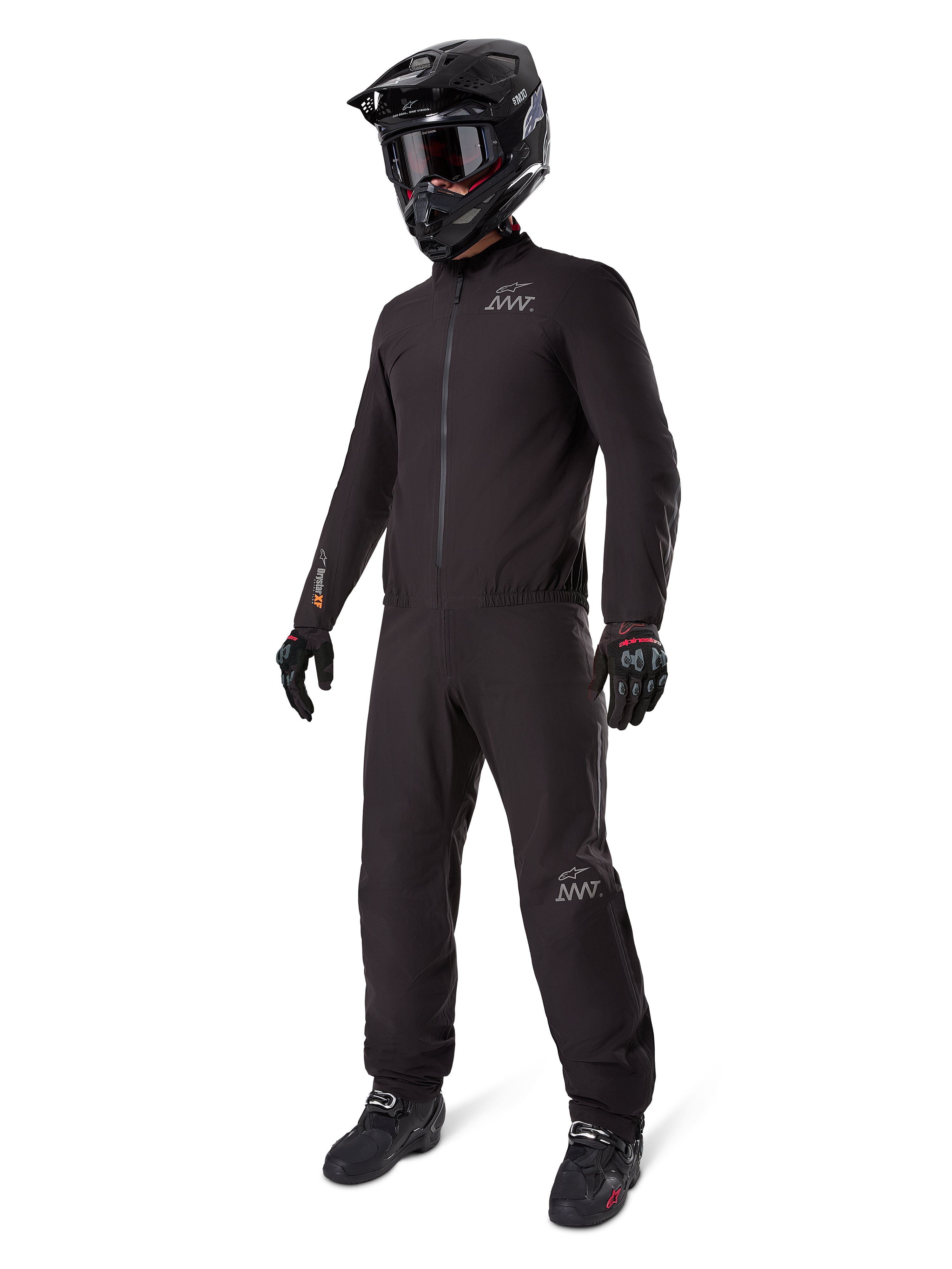 Forro Alpinestars AMT-8 Stretch Drystar® XF, traje de moto impermeable negro, usado con casco, gafas y guantes negros, con logotipos de AMT y Drystar XF, equipamiento de aventura funcional para protección en cualquier condición climática.