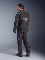 Chaqueta laminada Alpinestars Halo Pro Drystar® XF, chaqueta de moto adventure, negro Dark Shadow con detalles en rojo, vista posterior con pantalones y botas a juego, logotipo gris en la espalda, diseño textil modular para adventure touring