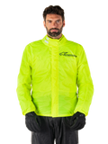 Alpinestars Hurricane Rain V2 Jacket, chaqueta impermeable para moto, amarillo flúor, usada por un modelo con pantalones y guantes negros, cuello alto con pestañas reflectantes, solapa frontal contra tormentas con el logo de Alpinestars, equipo impermeable de alta visibilidad