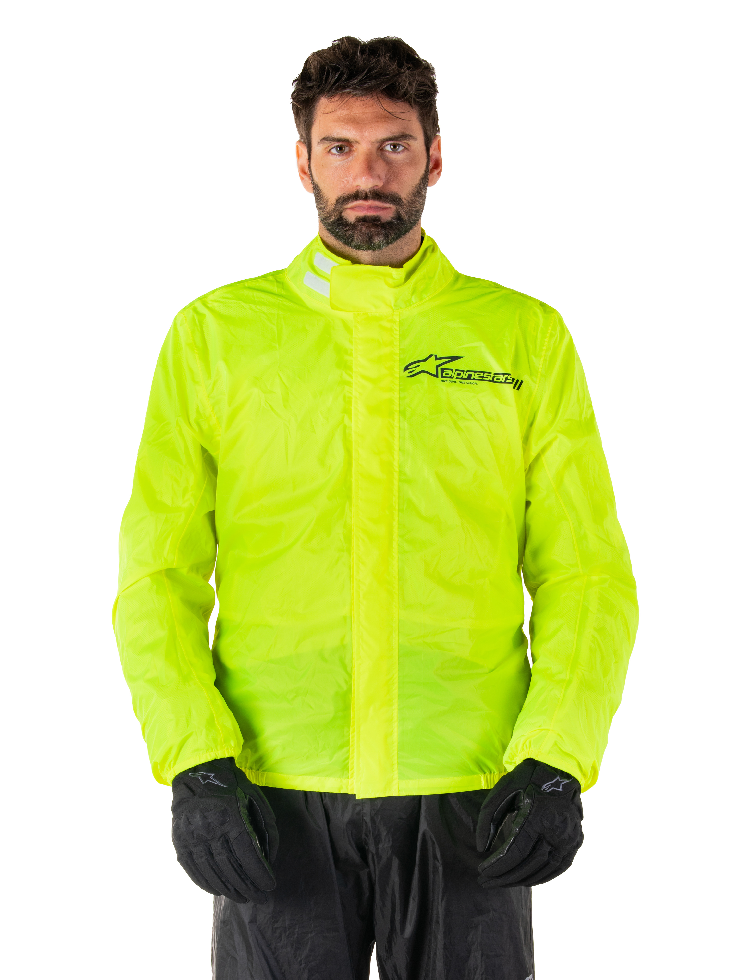 Alpinestars Hurricane Rain V2 Jacket, chaqueta impermeable para moto, amarillo flúor, usada por un modelo con pantalones y guantes negros, cuello alto con pestañas reflectantes, solapa frontal contra tormentas con el logo de Alpinestars, equipo impermeable de alta visibilidad