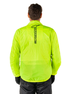 Chaqueta Alpinestars Hurricane Rain V2, chaqueta impermeable para moto, amarillo flúor, vista trasera que muestra el logotipo vertical negro de Alpinestars en el centro de la espalda, tejido impermeable ligero, usada con pantalones de moto y guantes negros