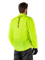 Chaqueta Alpinestars Hurricane Rain V2, Amarillo Fluo, vista trasera en un modelo masculino, con el logotipo vertical de Alpinestars en negro en el centro de la espalda, cintura y puños elásticos, diseño impermeable y plegable