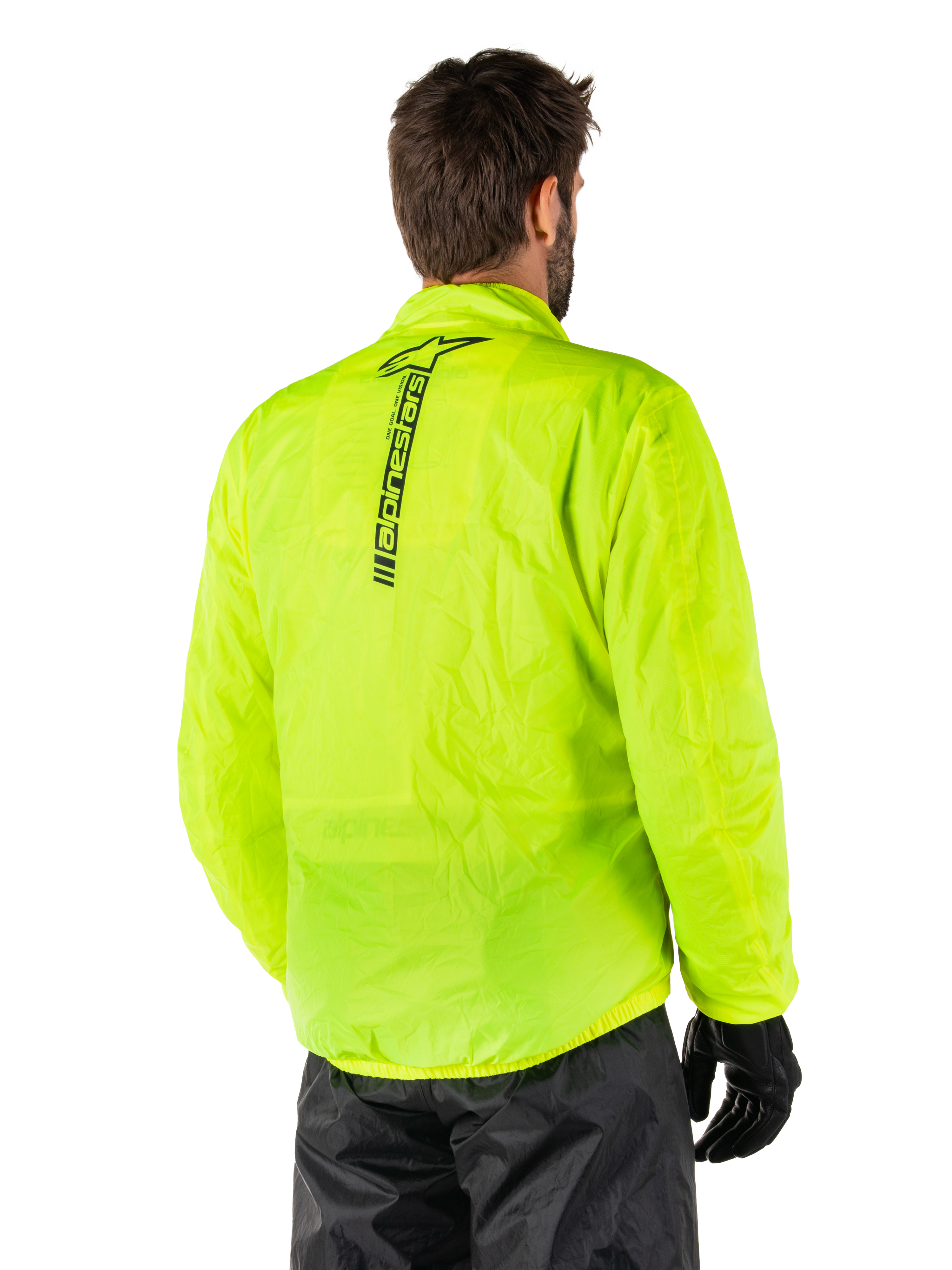 Chaqueta Alpinestars Hurricane Rain V2, Amarillo Fluo, vista trasera en un modelo masculino, con el logotipo vertical de Alpinestars en negro en el centro de la espalda, cintura y puños elásticos, diseño impermeable y plegable