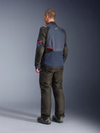Chaqueta Alpinestars Andes V4 Drystar®, azul noche y azul índigo con paneles negros y detalles rojos, vista trasera en tres cuartos, combinada con pantalones de aventura y botas negras a juego, construcción en tejido técnico con logotipo de Alpinestars en la parte superior trasera y dobladillo posterior alargado para mayor cobertura.