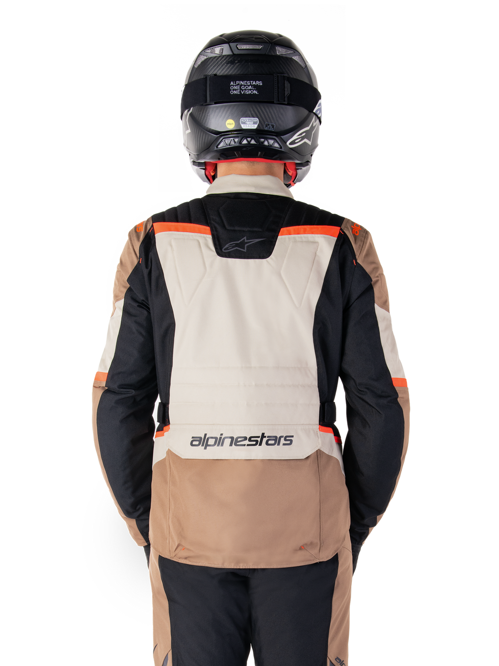 Chaqueta impermeable Alpinestars ST-1, Dark Khaki Sand Black Red Fluo, vista trasera, chaqueta de motociclismo adventure touring con un gran panel trasero de color arena, mangas negras y detalles en rojo fluorescente, mostrada en un piloto con casco negro.