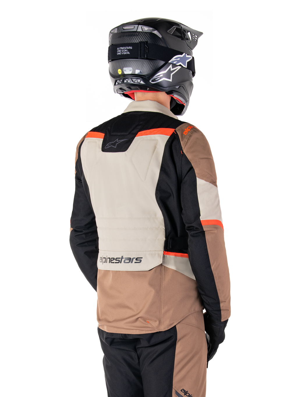 Chaqueta Alpinestars ST-1 Waterproof, chaqueta de touring de aventura, caqui oscuro, arena, negro y rojo flúor, vista trasera que muestra paneles textiles con bloques de color, detalles en rojo fluorescente y el logotipo de Alpinestars en la parte inferior de la espalda, usada por un piloto con un casco negro.