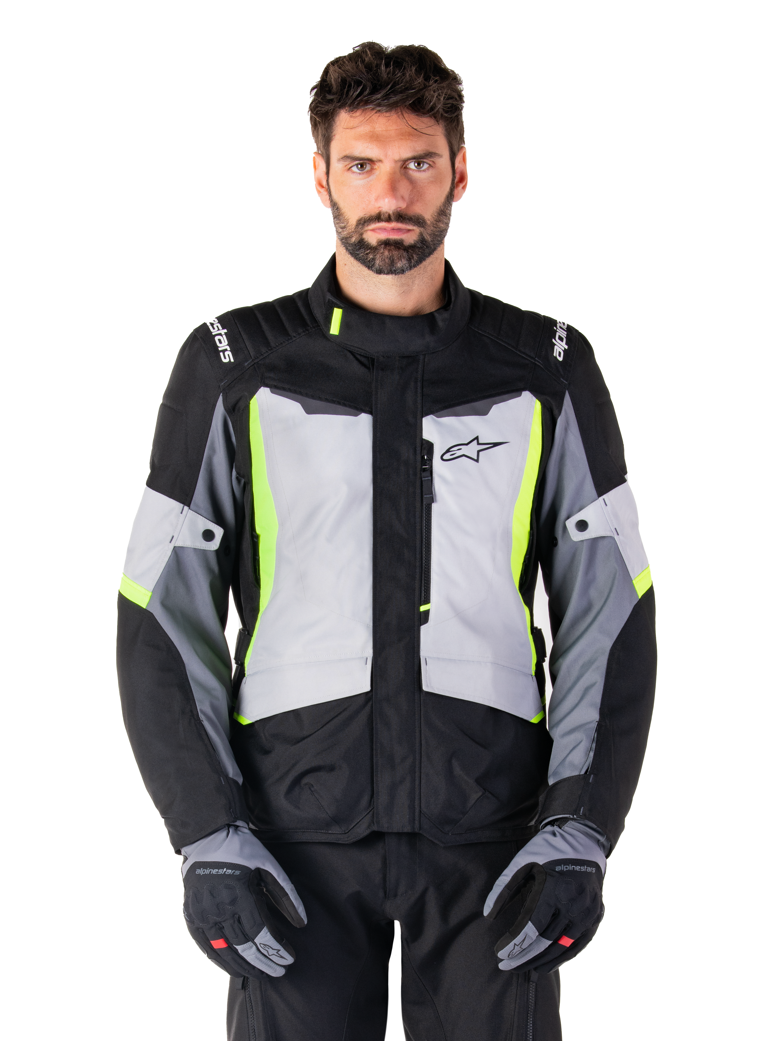 Alpinestars ST-1 Waterproof Jacket, adventure touring motorcycle jacket, Ice Gray Black and Yellow Fluo, worn by a man with matching gloves and black pants, featuring neon yellow accents on the chest and collar, Alpinestars logo on the chest