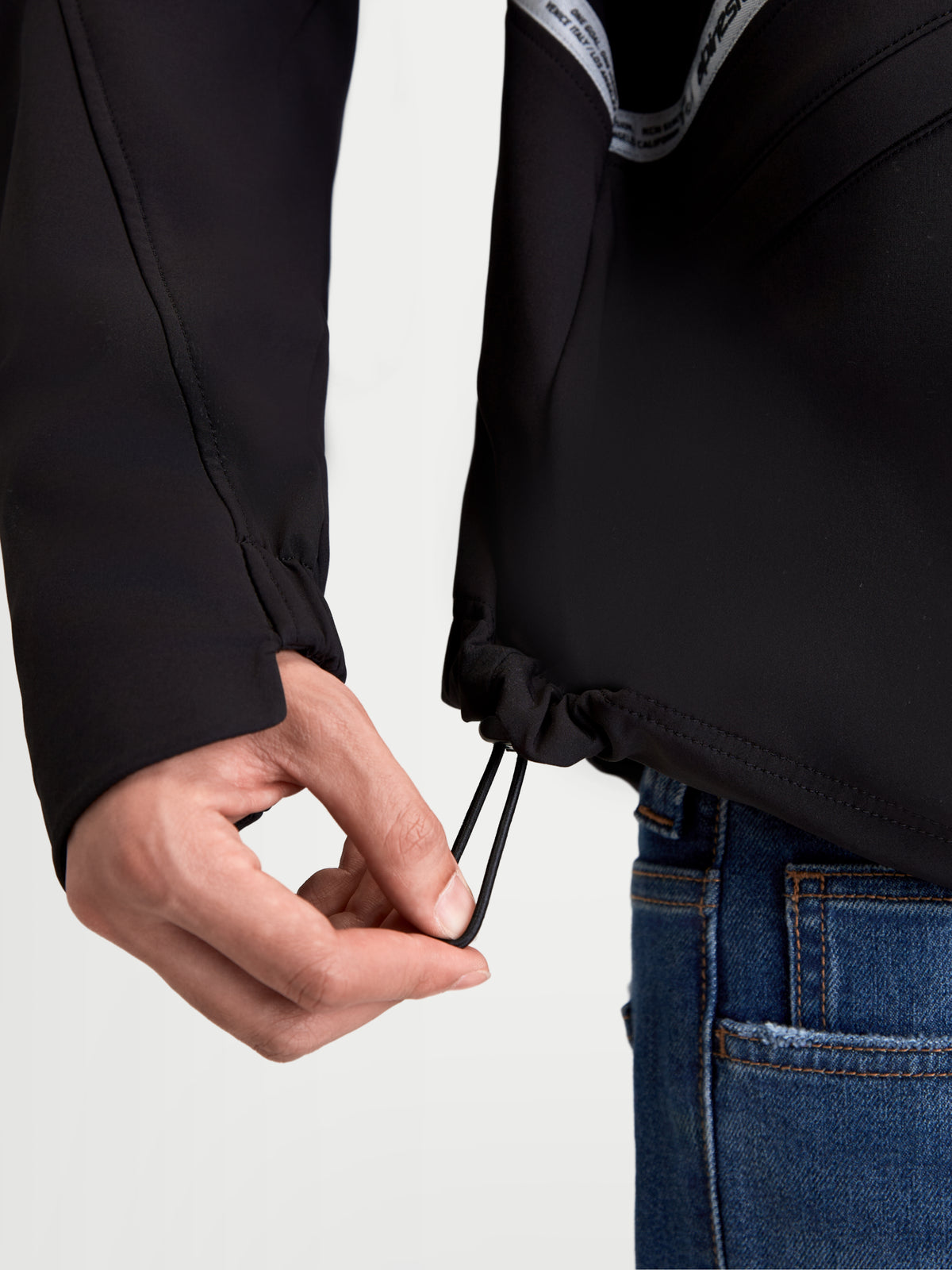 Alpinestars C 5 Drystar Chaqueta, chaqueta de moto urbana textil para hombre en negro, vista de primer plano que muestra el ajuste del cordón elástico en el dobladillo inferior y el puño elástico