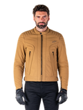 Chaqueta Alpinestars Clayton WR, chaqueta de moto urbana, color Utility Brown Light Gold, textil resistente al agua con hombros acolchados, cuello alto de motorista, detalles de cremalleras negras y logo en el pecho, usada con guantes de protección y pantalones negros