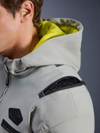 Chaqueta Alpinestars Moblast WP, Gris Hierro, primer plano del hombro con el compartimento del protector Nucleon Flex abierto, interior de la capucha en amarillo neón, equipamiento técnico urbano para motociclista con cremalleras funcionales