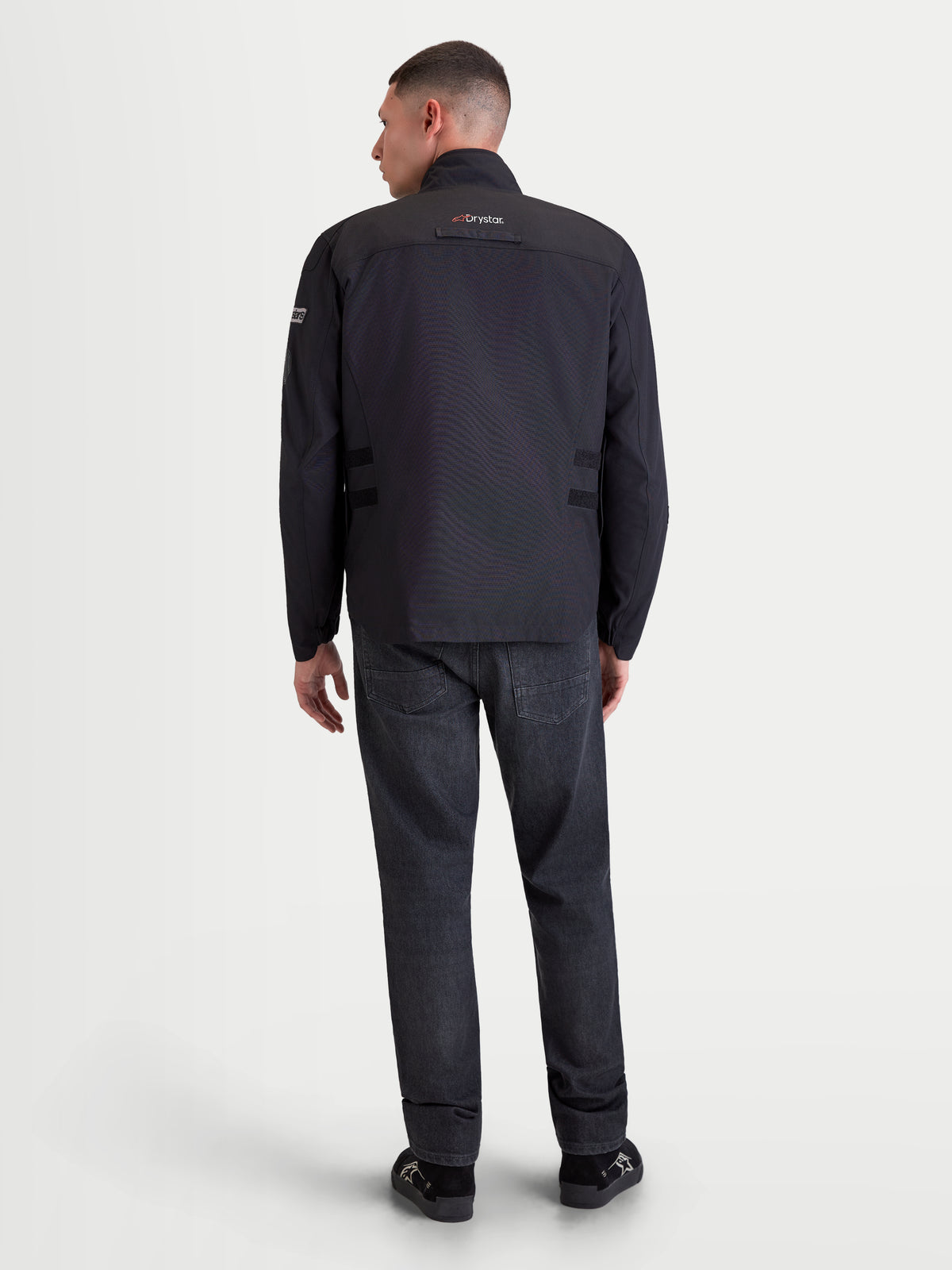 Alpinestars Altan Drystar Chaqueta, chaqueta de moto urbana contemporánea para hombre, negra, vista trasera en un modelo que muestra la construcción impermeable con cuello integrado y detalles Drystar