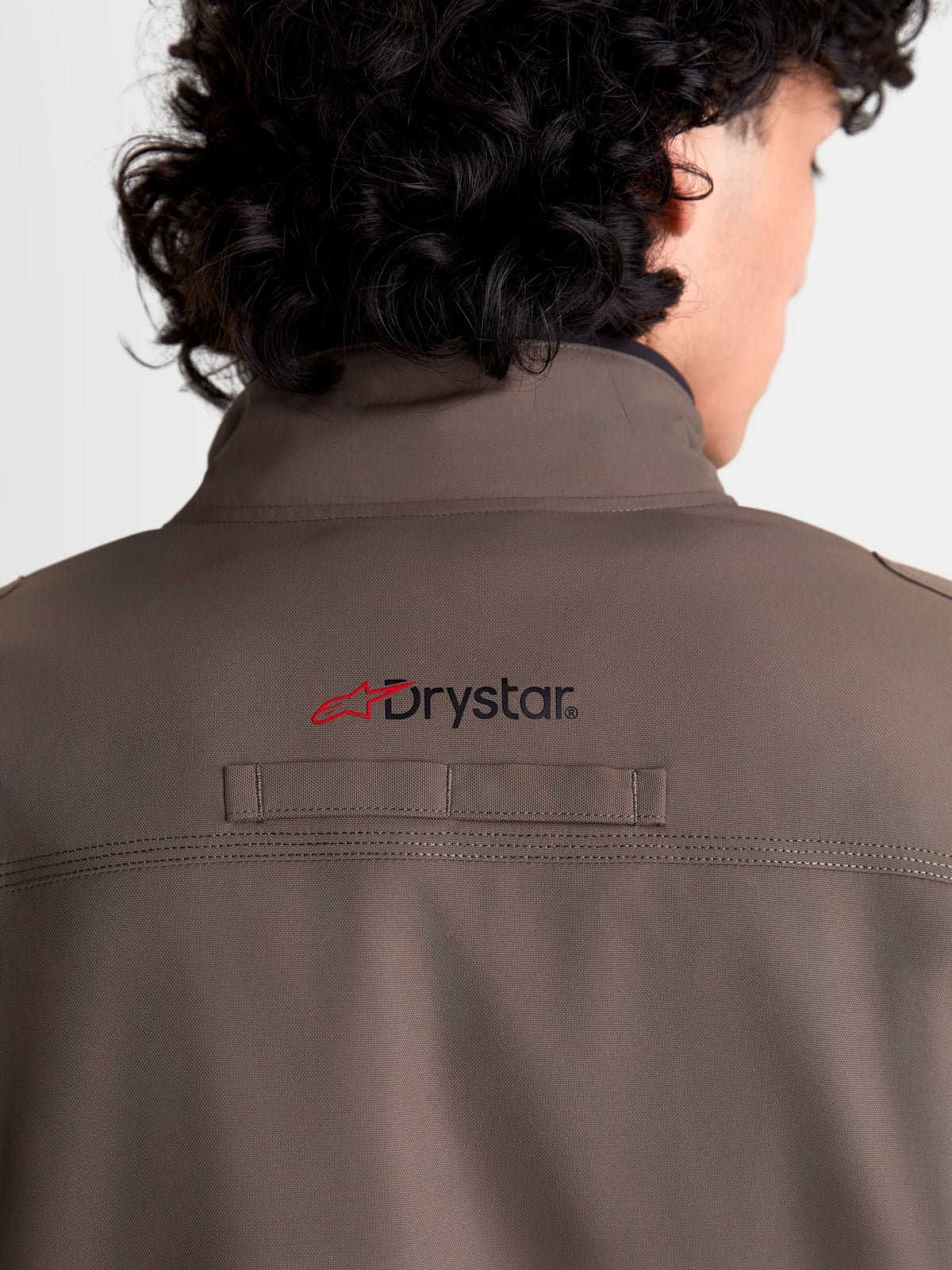 Alpinestars Altan Drystar Jacket, men's urban contemporary waterproof motorcycle jacket in walnut and black, rear close-up view showing the integrated warm collar, Drystar branding on the back, and durable polyfabric construction.