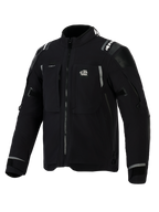 Chaqueta Alpinestars Andes Pro Drystar® XF, chaqueta de aventura para motocicleta en color negro y gris oscuro, vista frontal en ángulo, con el logotipo 'ALL TERRA' en el pecho, detalles reflectantes en los hombros, múltiples bolsillos impermeables con cremallera y puños ajustables.