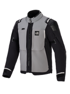 Chaqueta Alpinestars Andes Pro Drystar® XF, chaqueta de moto de aventura, gris oscuro y negro, con paneles grises en el pecho, mangas y laterales negros, marca 'ALL TERRA' en el pecho, logotipo de Alpinestars en los hombros, construcción textil técnica con cremalleras de ventilación y puños ajustables.