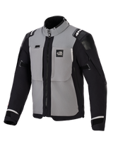 Chaqueta Alpinestars Andes Pro Drystar® XF, chaqueta de moto de aventura, gris oscuro y negro, con paneles grises en el pecho, mangas y laterales negros, marca 'ALL TERRA' en el pecho, logotipo de Alpinestars en los hombros, construcción textil técnica con cremalleras de ventilación y puños ajustables.