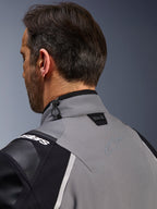 Chaqueta Alpinestars Andes Pro Drystar® XF, gris oscuro y negro, primer plano del cuello posterior y la parte superior del hombro, con el logotipo Tech-Air® Ready, ajuste de cordón elástico y logotipo tonal de la estrella Alpinestars sobre tejido técnico