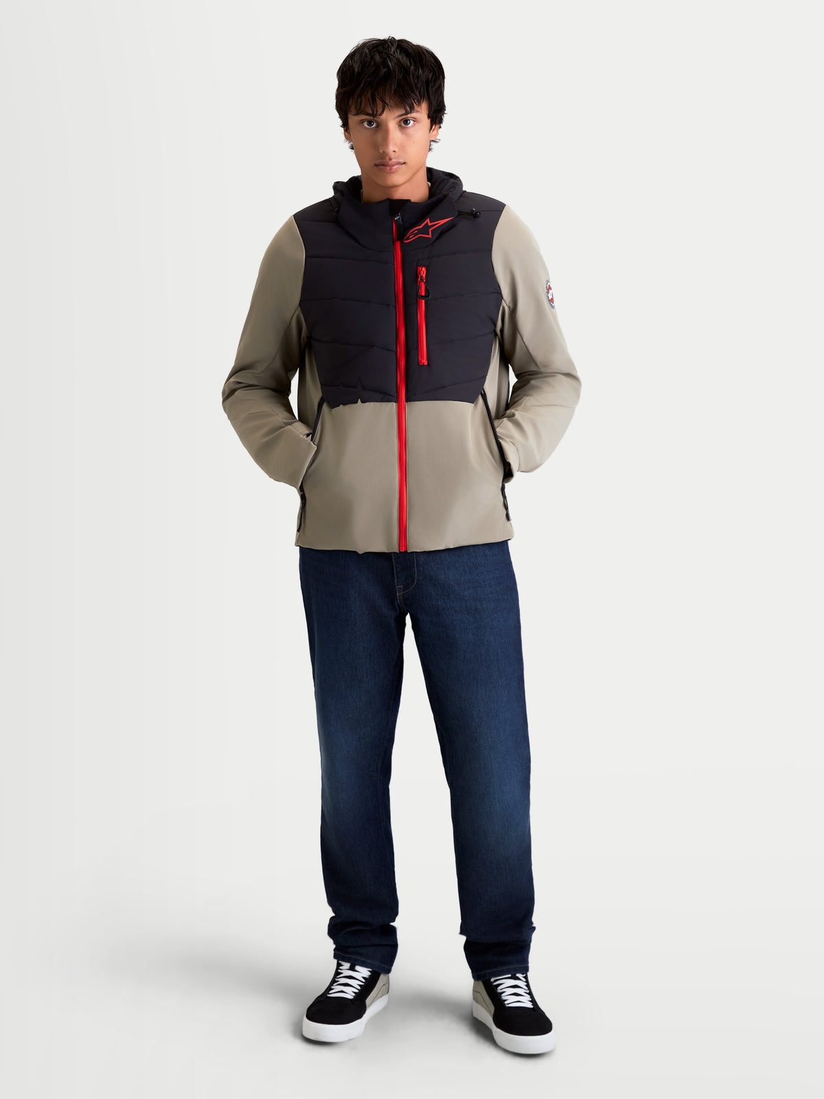 Alpinestars Therma-Tech Chaqueta impermeable, chaqueta de moto urbana contemporánea para hombre en negro y vetiver, vista frontal de un modelo que lleva la chaqueta aislante con una cremallera frontal roja y construcción acolchada en el pecho