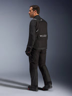 Chaqueta Alpinestars Cusco Drystar®, chaqueta de moto negra, vista posterior de un modelo masculino con equipamiento completo de conducción, con logotipos reflectantes en la espalda, construcción textil con paneles técnicos, conjunto coordinado para touring de aventura en carretera