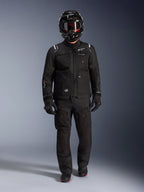 Chaqueta Alpinestars Cusco Drystar®, chaqueta negra de moto para aventura y touring, combinada con pantalones negros a juego, casco integral, guantes y botas, con construcción técnica de ripstop y logotipos blancos de Alpinestars