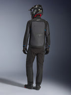 Chaqueta Alpinestars Cusco Drystar®, negro y gris oscuro, vista trasera de un piloto con equipamiento completo de adventure touring, gran panel trasero gris con el logotipo de Alpinestars, detalles azules en las mangas, usada con pantalones negros y casco a juego.