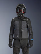 Chaqueta Alpinestars Cusco Drystar®, negro y gris oscuro, chaqueta de adventure touring para motocicleta usada con pantalones técnicos negros a juego y un casco dual-sport, con un diseño en dos tonos con paneles de ripstop y logotipos de Alpinestars