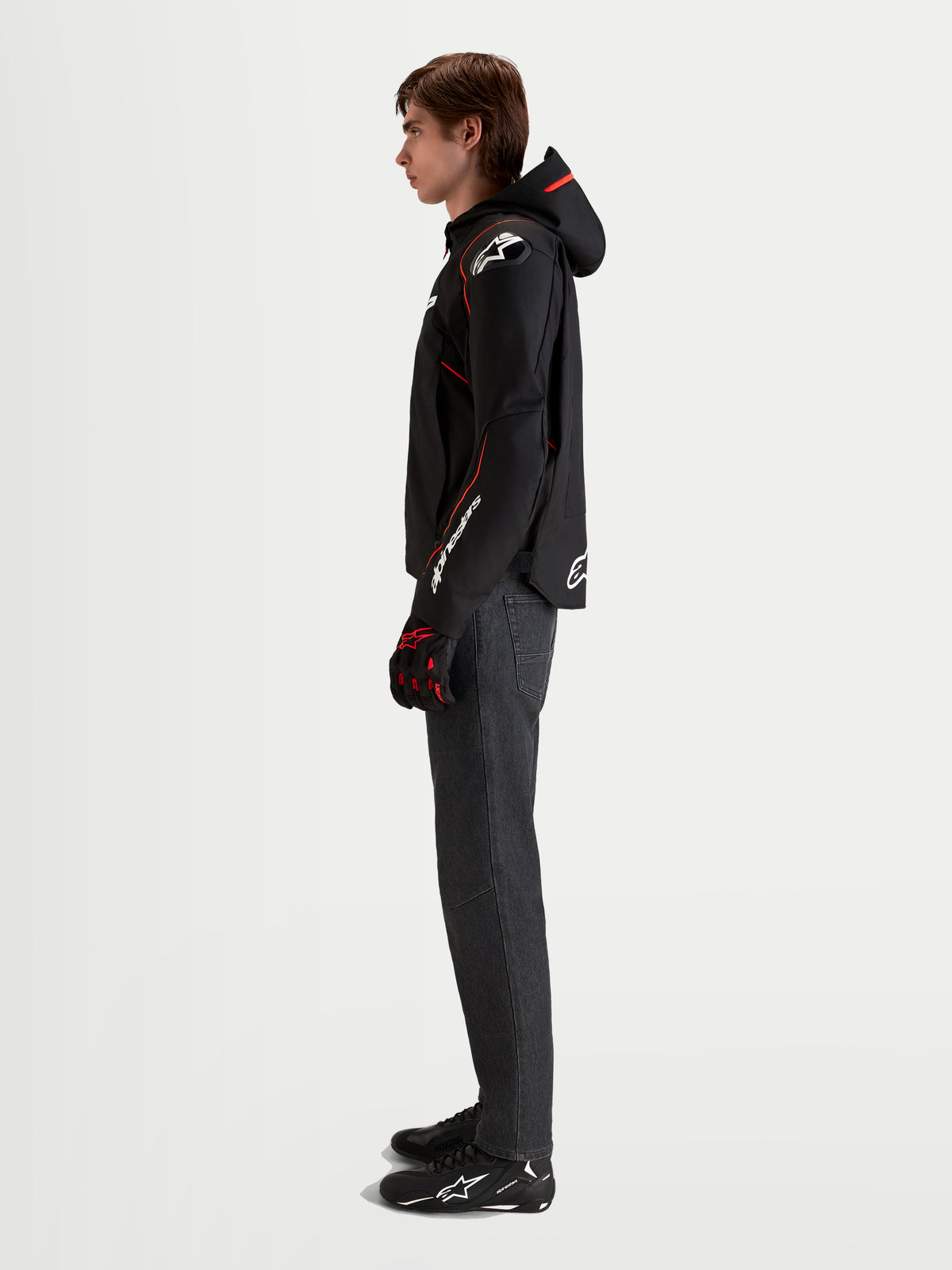 Alpinestars Zaca V2 Waterproof Chaqueta, chaqueta de moto deportiva para hombre en negro y rojo fluo, con capucha integrada, protección de hombros DFS y mangas precurvadas, vista de perfil en modelo