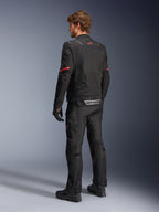 Alpinestars ST-2 Air Jacket, Black motorcycle jacket, rear view on model featuring a red star logo on the upper back and reflective Alpinestars branding at the waist, paired with matching black technical riding pants and gloves.