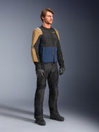 Piloto con la chaqueta Alpinestars ST-2 Air en azul profundo, caqui oscuro y negro, con grandes paneles de malla y perforaciones láser, combinada con pantalones de motociclista, guantes y botas negras para un look completo de turismo de verano.