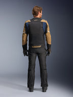 Chaqueta Alpinestars ST-2 Air en azul profundo, caqui oscuro y negro, vista trasera en modelo que muestra el gran panel de malla en la espalda y mangas caqui con rayas blancas, combinada con pantalones técnicos de moto y guantes negros para turismo de aventura.