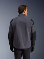 Alpinestars Maxdura Drystar®XF Laminated Armored Shell, chaqueta técnica de aventura, gris oscuro y negro, vista trasera con paneles reforzados en hombros y codos, sutil logo en la parte superior de la espalda, usada con guantes y pantalones negros, diseñada para protección en todo tipo de clima
