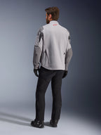 Maxdura Drystar®XF Laminated Armored Shell, chaqueta de moto, gris medio y gris oscuro, vista trasera con el logo rojo de Alpinestars en el cuello, refuerzos gris oscuro en las mangas, usada con pantalones y botas negros, equipamiento para conducción de aventura
