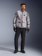 Alpinestars Maxdura Drystar®XF Laminated Armored Shell, chaqueta de aventura para moto, gris medio y gris oscuro con detalles rojos, usada con pantalones y guantes de conducción negros, vista frontal que destaca su construcción técnica y bolsillos de carga.