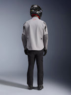 Alpinestars Maxdura Drystar®XF Laminated Armored Shell, chaqueta de moto en gris medio y gris oscuro, vista desde atrás en un piloto, usada con pantalones negros, botas negras y un casco blanco y negro, equipamiento para adventure touring
