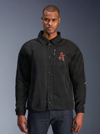 Alpinestars Revved WR Jacket, chaqueta de moto negra con cuello tipo camisa y cierre frontal de botones a presión, logotipo 'A' rojo bordado en el pecho, bolsillo vertical con cremallera en el pecho, puños elásticos, diseño de chaqueta tipo coaches urbana