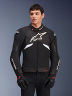 Alpinestars T-GP R V3 Drystar Jacket, chaqueta textil deportiva impermeable, negra y blanca con acentos rojos, con un gran logo de estrella blanca en el pecho y marca blanca en las mangas, usada con guantes de moto negros y rojos