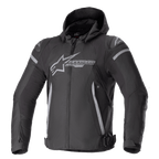Alpinestars Zaca Waterproof Jacket, chaqueta deportiva para moto, negro y gris oscuro, con capucha desmontable, logotipo grande gris en el pecho, detalles en gris claro en los hombros y laterales, correas de ajuste en la cintura y cierre frontal de cremallera, confección textil deportiva