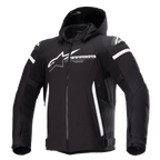 Alpinestars Zaca Waterproof Jacket, chaqueta de moto negra con capucha desmontable, gran logotipo blanco de Alpinestars en el pecho, rayas blancas en la parte superior de los brazos y detalles laterales verticales, cremallera frontal, acolchado reforzado en los hombros, correas ajustables en la cintura y los brazos, construcción en tejido softshell