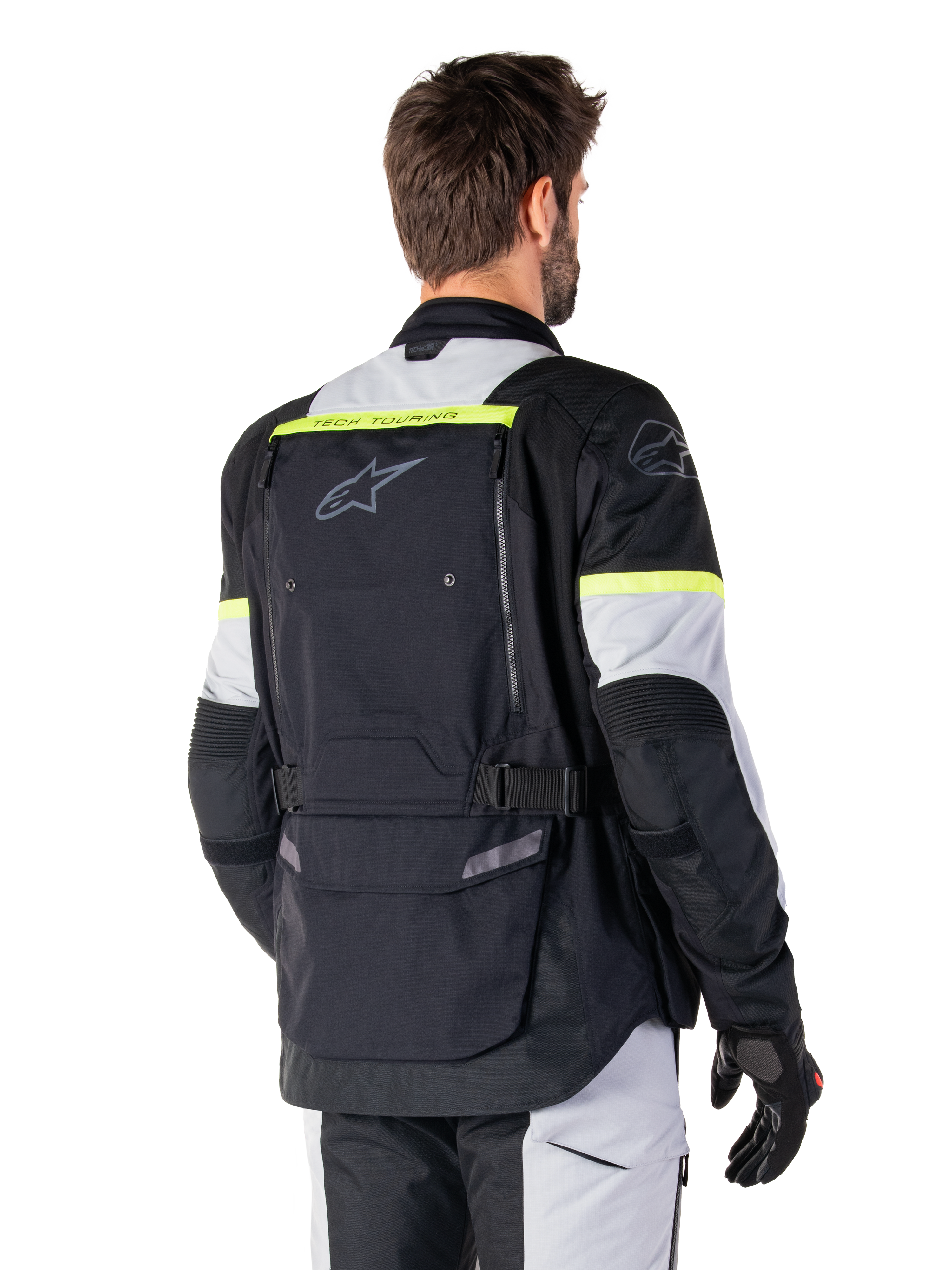 Chaqueta Alpinestars Bogotá Pro Drystar®, chaqueta adventure touring, negro, gris hielo y amarillo flúor, vista posterior con un gran panel de bolsillo trasero, marca 'TECH TOURING', logotipo de Alpinestars y detalles amarillos fluorescentes, equipamiento técnico de tejido textil
