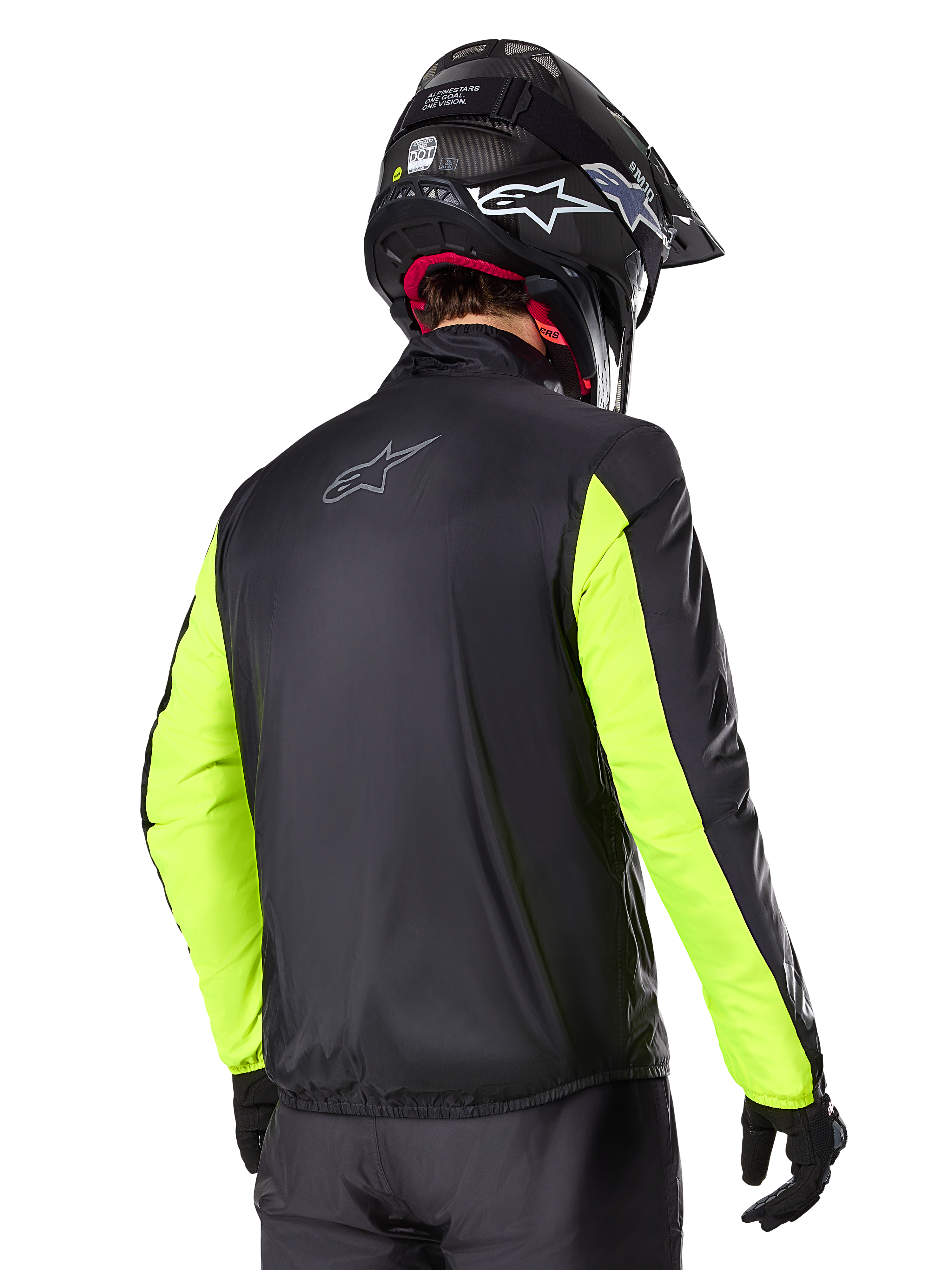 Chaqueta Alpinestars Bogotá Pro Drystar®, vista trasera, negra con mangas en amarillo flúor, usada por un piloto con casco y guantes negros, equipamiento de moto de alta visibilidad para adventure touring con acabado textil técnico.