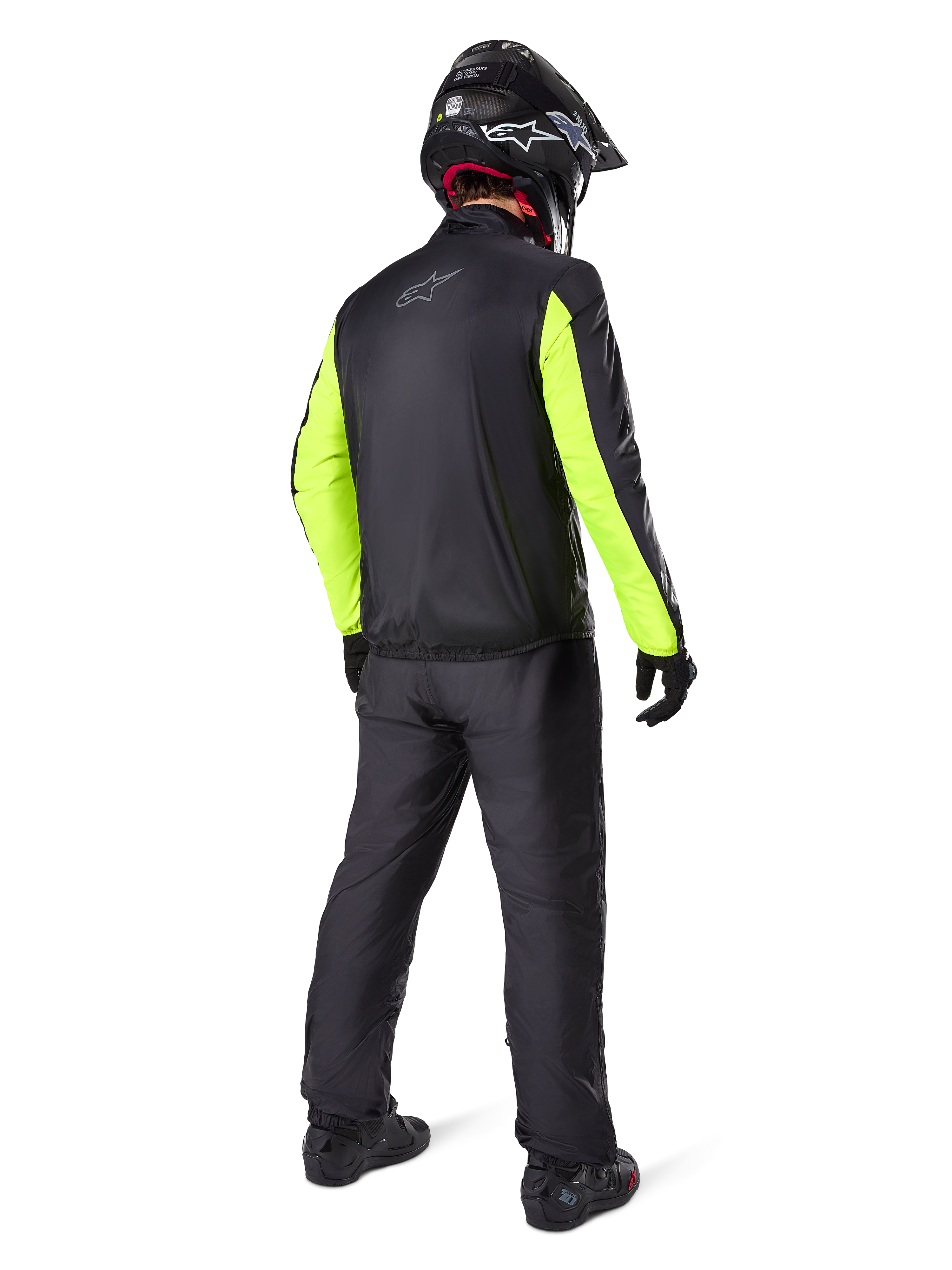 Motorista visto desde atrás con la chaqueta Alpinestars Bogotá Pro Drystar®, negra con mangas amarillo flúor, pantalones y casco negros a juego, equipamiento técnico de aventura para todas las estaciones