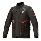 Honda Andes V3 Drystar Jacket, Motorcycle Touring Jacket, Black with Red Accents, front view featuring large cargo pockets and adjustable straps, technical textile construction with Honda wing and Alpinestars logos, adventure-inspired design