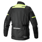 Alpinestars Andes V3 Drystar® Jacket, vista trasera de chaqueta de moto de aventura en color negro y amarillo flúor, con un gran bolsillo utilitario en la parte baja de la espalda con el logotipo de Alpinestars, paneles de alta visibilidad en los hombros y correas de ajuste en la cintura.