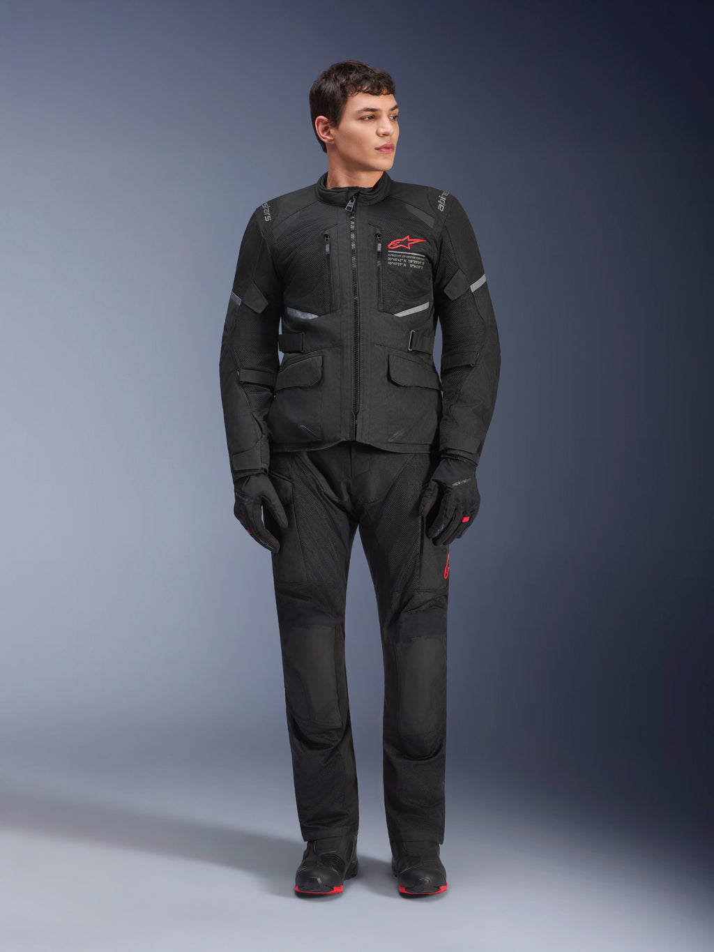 Pantalones Alpinestars Andes Air Drystar®, pantalones de moto para turismo, color negro, con paneles de ventilación de malla y un logotipo rojo en la pierna, lucidos como parte de un conjunto de equipación completo con chaqueta y guantes a juego, equipamiento profesional para motociclismo de aventura