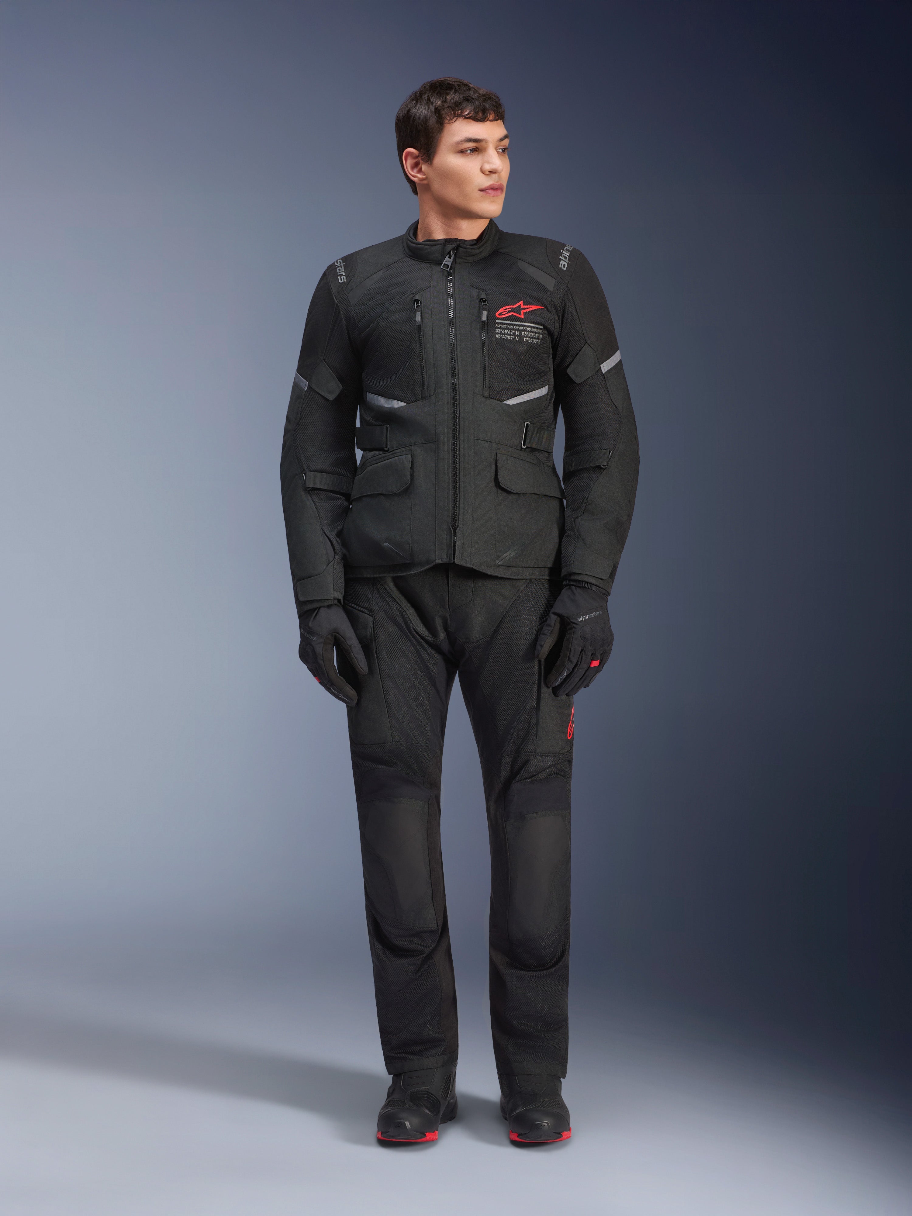 Pantalones Alpinestars Andes Air Drystar®, pantalones de moto para turismo, color negro, con paneles de ventilación de malla y un logotipo rojo en la pierna, lucidos como parte de un conjunto de equipación completo con chaqueta y guantes a juego, equipamiento profesional para motociclismo de aventura