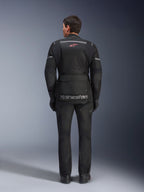Chaqueta y pantalones Alpinestars Andes Air Drystar®, conjunto de motociclismo touring en negro, vista trasera del piloto, con paneles de malla, logotipo de estrella roja y marca reflectante Alpinestars en la chaqueta, combinado con guantes y botas negros