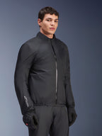 Membrana impermeable de la chaqueta Alpinestars Andes Air Drystar®, negra, usada por un modelo masculino con guantes y pantalones negros, textil técnico ligero con la marca 'Drystar' en la manga, toma de estudio